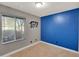 Cozy bedroom with neutral carpet, large window, and a blue accent wall at 19604 N 13Th Ave, Phoenix, AZ 85027
