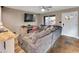 Open-concept living room view, showcasing large grey sofa and kitchen access at 19604 N 13Th Ave, Phoenix, AZ 85027