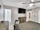 Well-lit bedroom showcasing a ceiling fan, television, and view into an ensuite bathroom at 19604 N 13Th Ave, Phoenix, AZ 85027