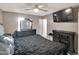 Serene bedroom with a ceiling fan, mounted TV, and coordinating dark wood furniture at 19604 N 13Th Ave, Phoenix, AZ 85027