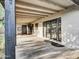 Relaxing covered patio with exposed beams, black framed glass doors, outdoor access and large concrete pavers at 19604 N 13Th Ave, Phoenix, AZ 85027