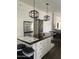 Bright kitchen featuring a large island with modern light fixtures and white cabinets at 2249 E Pinto Dr, Gilbert, AZ 85296