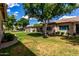 Lush backyard featuring mature trees, grassy lawn, and neighboring houses at 23813 S Pleasant Way, Sun Lakes, AZ 85248
