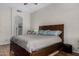 Spacious bedroom with fan and light fixture above bed, with hardwood flooring and views into adjacent bathroom at 23813 S Pleasant Way, Sun Lakes, AZ 85248