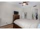 Bedroom with fan and light fixture above bed, walk in closet, and a television on dresser at 23813 S Pleasant Way, Sun Lakes, AZ 85248