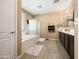Bright bathroom featuring a soaking tub, glass shower, double vanity, and neutral tile flooring at 25540 N 103Rd Dr, Peoria, AZ 85383