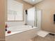 Bathroom showcasing a soaking tub under a window with a glass-enclosed shower next to it at 25540 N 103Rd Dr, Peoria, AZ 85383