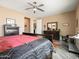 Comfortable bedroom with wood flooring, ceiling fan, dresser, and stylish bedding at 25540 N 103Rd Dr, Peoria, AZ 85383