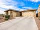 Spacious driveway leading to a well-maintained home with dual garages and neatly arranged desert landscaping at 25540 N 103Rd Dr, Peoria, AZ 85383