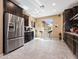 Well-lit kitchen featuring stainless steel appliances, dark wood cabinets, tile flooring, and ample counter space at 25540 N 103Rd Dr, Peoria, AZ 85383