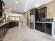 Open-concept kitchen with stainless steel appliances, dark wood cabinetry, breakfast bar, and adjacent dining area at 25540 N 103Rd Dr, Peoria, AZ 85383