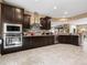 A spacious kitchen featuring dark cabinets, stainless steel appliances, and granite countertops, perfect for culinary enthusiasts at 25540 N 103Rd Dr, Peoria, AZ 85383