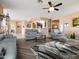 Inviting living room featuring hardwood floors, modern seating, and seamless flow to the adjacent kitchen area at 25540 N 103Rd Dr, Peoria, AZ 85383