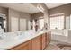 Bright bathroom with double sinks, a soaking tub, and natural light, offering a relaxing and functional space at 25845 N 44Th Ave, Phoenix, AZ 85083