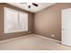 Minimalist bedroom design with neutral carpet and walls, plus a window and door, creating a blank canvas at 25845 N 44Th Ave, Phoenix, AZ 85083