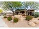 Single story home featuring desert landscaping, including rocks, red flowers and shade trees at 25845 N 44Th Ave, Phoenix, AZ 85083