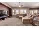Spacious living room featuring large sectional couch, neutral carpet, and lots of natural light at 25845 N 44Th Ave, Phoenix, AZ 85083