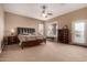 Inviting main bedroom with a luxurious bed, neutral walls, complemented by an ensuite entrance and a ceiling fan at 25845 N 44Th Ave, Phoenix, AZ 85083