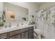 Bright bathroom featuring a vanity, large mirror, decorative shower curtain, and natural light at 25946 W Cat Balue Dr, Buckeye, AZ 85396