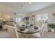Bright dining area with a round table, a window with blinds, and views into the spacious living room at 25946 W Cat Balue Dr, Buckeye, AZ 85396