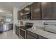 Modern kitchen features stainless steel appliances, granite countertops, and dark wood cabinets at 25946 W Cat Balue Dr, Buckeye, AZ 85396