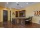 Entertaining bar area featuring granite countertop, dark wood cabinets, and comfortable seating for guests at 26156 N 88Th Way, Scottsdale, AZ 85255