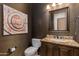 Stylish bathroom with a granite countertop, decorative mirror, and modern commode set against textured wall coverings at 26156 N 88Th Way, Scottsdale, AZ 85255