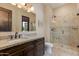 Well-lit bathroom featuring a dark wood vanity, granite countertop, and a glass-enclosed shower for a spa-like experience at 26156 N 88Th Way, Scottsdale, AZ 85255
