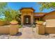 Inviting home entrance with stone accents, a custom iron door, and desert landscaping at 26156 N 88Th Way, Scottsdale, AZ 85255
