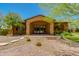 Inviting single-story home featuring a grand arched entrance, stone accents, and beautifully landscaped front yard at 26156 N 88Th Way, Scottsdale, AZ 85255