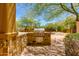 Outdoor grilling area with stone facade, built in appliances, and lush landscaping, ideal for entertaining friends and Gathering at 26156 N 88Th Way, Scottsdale, AZ 85255