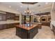 Gourmet kitchen featuring dark wood cabinets, granite countertops, and a central island at 26156 N 88Th Way, Scottsdale, AZ 85255