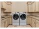 Laundry room with dual front load washer and dryer, granite counters, and cabinetry, providing ample space at 26156 N 88Th Way, Scottsdale, AZ 85255