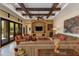 Comfortable living room with wood beam ceilings, a built-in entertainment center, and travertine floors at 26156 N 88Th Way, Scottsdale, AZ 85255