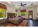 Spacious main bedroom with a large bed, sitting area, and view of the pool and yard through the windows at 26156 N 88Th Way, Scottsdale, AZ 85255