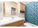 A bathroom with wood-finished vanity and cabinetry, with a bathtub featuring a blue patterned shower curtain at 3134 E Mckellips Rd # 139, Mesa, AZ 85213