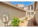 A side view of a townhome with beige siding, showcasing a walkway, minimal landscaping, and an external meter at 3134 E Mckellips Rd # 139, Mesa, AZ 85213