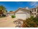A well maintained townhome garage featuring a white door, adjacent to a blooming flower bed and palm tree at 3134 E Mckellips Rd # 139, Mesa, AZ 85213