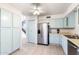A well-lit kitchen with stainless steel refrigerator, blue cabinets and tile floors, with pantry space nearby at 3134 E Mckellips Rd # 139, Mesa, AZ 85213