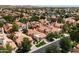Stunning aerial view of a neighborhood with terra cotta roofs, lush trees, and a serene lake at 3234 E Briarwood Ter, Phoenix, AZ 85048