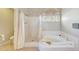 Bathroom featuring a separate shower and tub, complemented by tiled floors and an arched window at 3234 E Briarwood Ter, Phoenix, AZ 85048