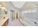 Bright bathroom with a tub, shower, vanity, and arched window at 3234 E Briarwood Ter, Phoenix, AZ 85048