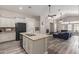 Open-concept kitchen and living room featuring a stone fireplace, ceiling fans, and wood floors at 3580 E Kesler Ln, Gilbert, AZ 85295