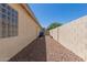 Side yard with rock landscaping and stucco privacy wall at 3580 E Kesler Ln, Gilbert, AZ 85295
