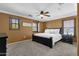 Comfortable bedroom features carpeted floors, a ceiling fan, and three windows providing ample natural light at 3828 S Verbena Ave, Gilbert, AZ 85297