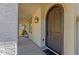 Arched front door with a sconce overhead, leading to a cozy and inviting home entrance at 3828 S Verbena Ave, Gilbert, AZ 85297