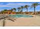 Spacious community pool surrounded by palm trees and comfortable seating areas at 3828 S Verbena Ave, Gilbert, AZ 85297