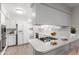 Bright kitchen features white cabinetry, modern appliances, and a breakfast bar with cooktop at 4106 W Mission Ln, Phoenix, AZ 85051