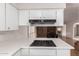 Close up of a kitchen counter with cooktop, leading into the dining area at 4106 W Mission Ln, Phoenix, AZ 85051