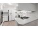 Bright kitchen features white cabinetry, modern appliances, and a breakfast bar with cooktop at 4106 W Mission Ln, Phoenix, AZ 85051